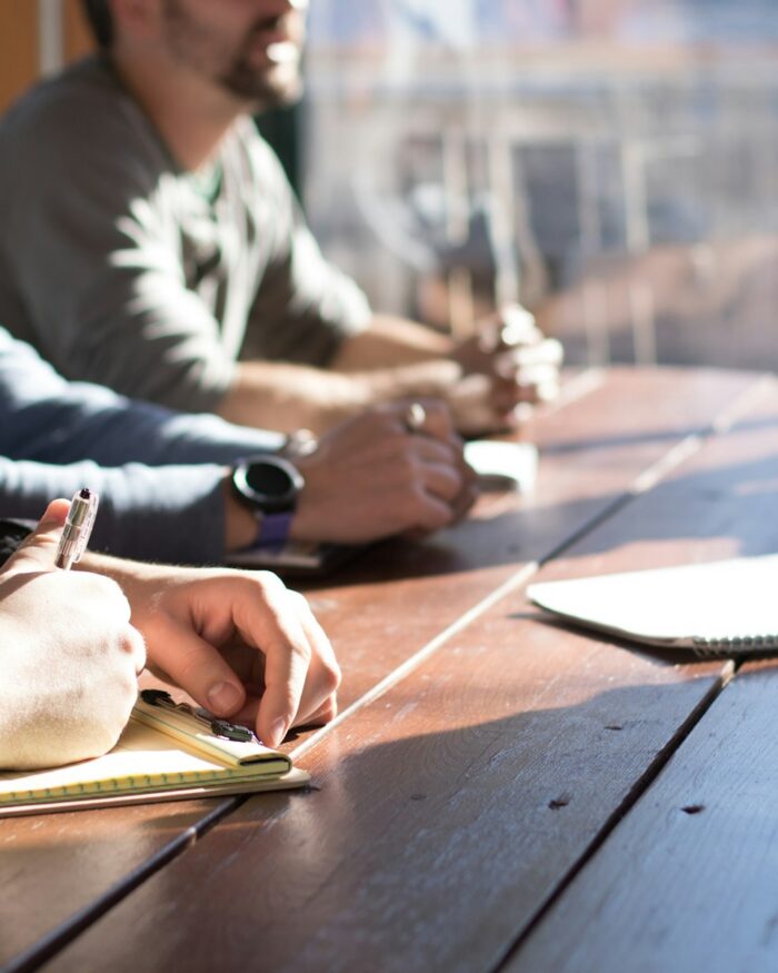Collega's in overleg rond een vergadertafel